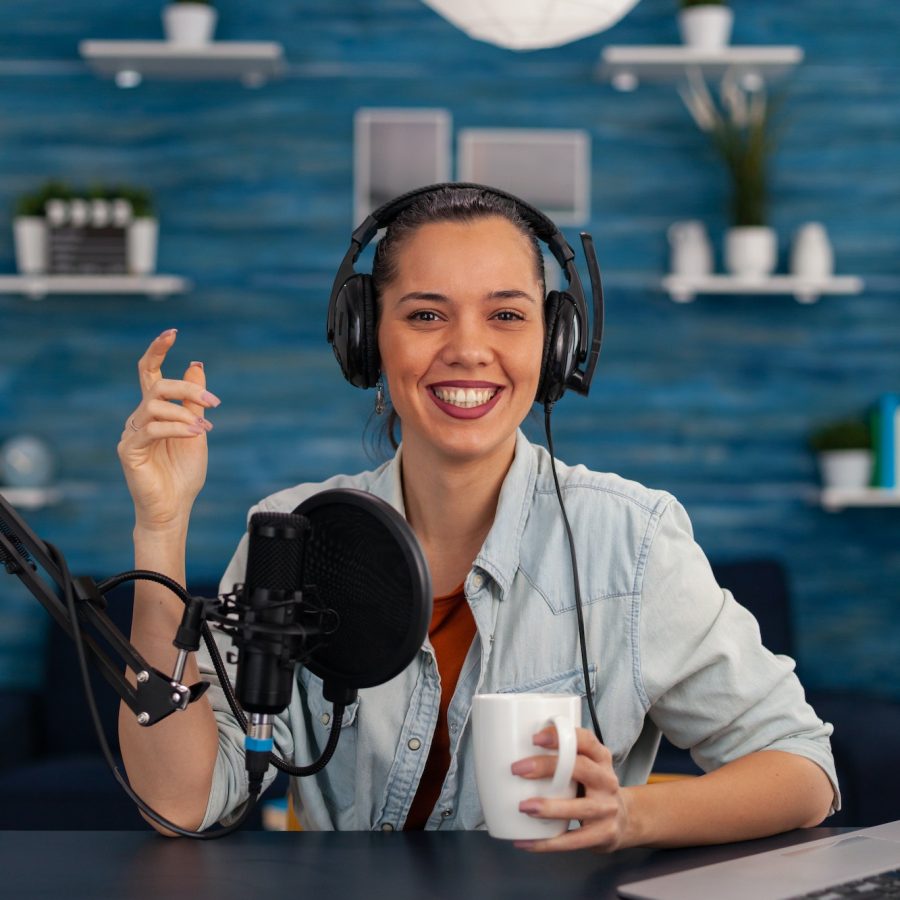 portrait-of-happy-woman-facing-camera-recording-in-home-studio.jpg